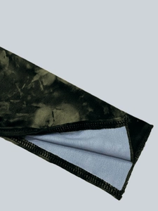 Détail du tissu de la robe avec imprimé camouflage vert et coutures surjetées premium