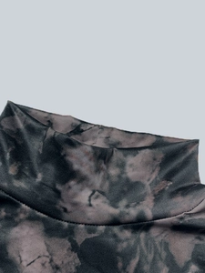 Détail du col montant avec imprimé marbré tie-dye foncé sur un tissu en maille douce