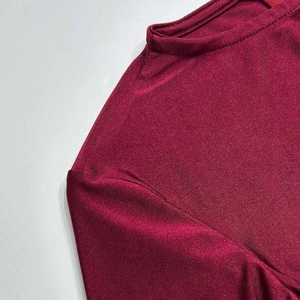 Close-up of wine red slim-fit dress fabric with ribbed texture and mock neck detail