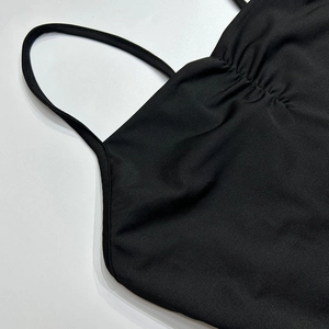 Détail d'une robe licou noire avec de fines bretelles et un décolleté plissé élégant