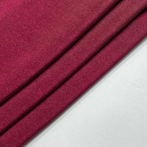 Macro detail of the wine red ribbed fabric texture on the slim fit cocktail dress