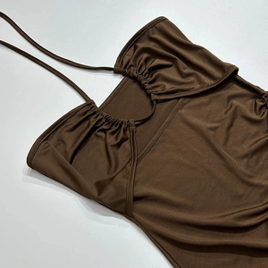 Détail de la robe dos nu marron foncé montrant les plis froncés et le tissu satiné