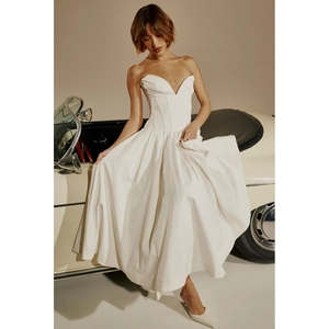Détail de robe bustier blanche avec corsage baleiné et jupe en satin près d'une auto