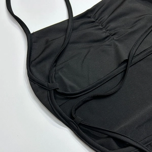 Détails des bretelles croisées et taille plissée sur robe dos nu noire chic