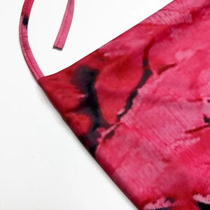 Gros plan sur la texture du tissu tie-dye rose et noir avec détail de fine bretelle