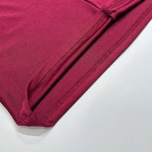 Detailed close-up showing double needle hem and knit texture on the burgundy dress