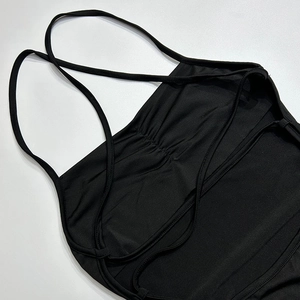 Détail des bretelles croisées au dos et du décolleté plissé sur une robe noire