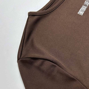 Detailed view of the brown crewneck knit top showing the soft fabric texture and neck print