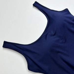 Close-up of seamless dark blue athletic fabric showing neck stitching and wide strap detail