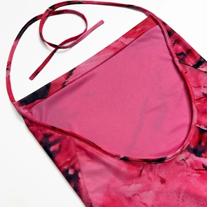 Détail du licou croisé sur robe moulante tie-dye rose vif avec textures de couture