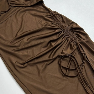 Détail de la couture latérale froncée et du cordon réglable sur la robe marron
