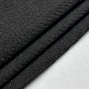 Gros plan sur le tissu en maille côtelée noire montrant la texture douce et les détails