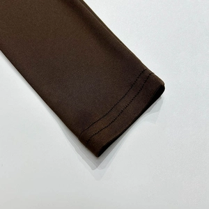 Close-up of double-stitched cuffs on brown long-sleeve knit top with ribbed texture