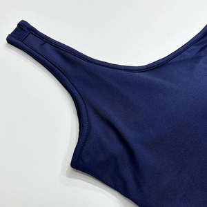 Detailed close-up of navy blue athletic bodysuit fabric showing precision stitching