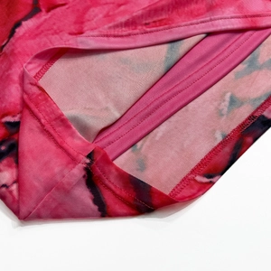Détail du tissu en maille tie-dye rose et de l'ourlet à double couture d'une robe