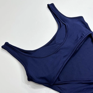 Close-up of navy blue sports bodysuit showing layered cutout neckline and knit texture