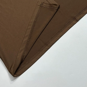 Vue détaillée des coutures doubles et de la texture du tissu marron café de la robe