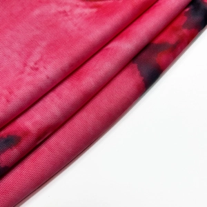 Détail macro du tissu en maille respirante rose tie-dye à texture rubis vive