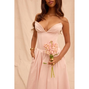 Détail de robe bustier rose clair avec corset baleiné et plis en V sur l'encolure