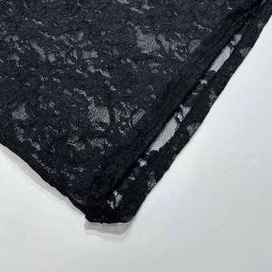 Detailaufnahme der feinen schwarzen Blumenspitze und der sauberen Saumnaht am Kleid