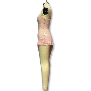Détail de la robe caraco en dentelle rose avec volants en mousseline et fente latérale