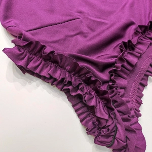Détails des volants violet foncé et coutures sur un tissu élastique de qualité