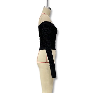 Detail eines schwarzen schulterfreien Netzoberteils mit gerafften langen Ärmeln am Torso