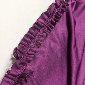 Détail de couture à volants violet foncé élégant sur une robe de soirée en maille premium