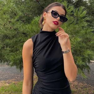 Detailed close-up of a sleeveless black midi dress with ruched side waist detail
