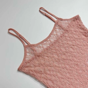 Macro d'un caraco en dentelle rose clair avec texture florale et fines bretelles