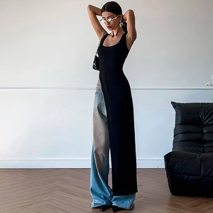 Women's chic black sleeveless high-slit top paired with wide-leg blue denim jeans