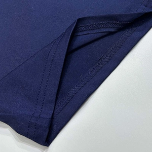 Gros plan détaillé des coutures à double aiguille et du tissu de la barboteuse bleu foncé