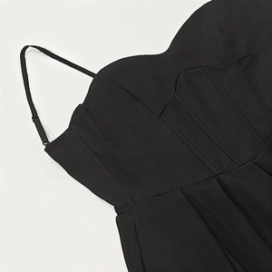 Detail of black V-neck corset dress showing sweetheart neckline and adjustable straps