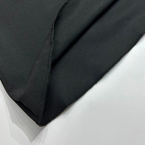 Gros plan des coutures de haute qualité et de l'ourlet sur une robe noire en A