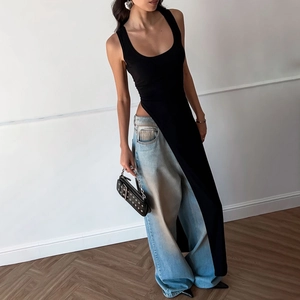 Detail of high side slit on slim black sleeveless top with vintage blue wide-leg jeans