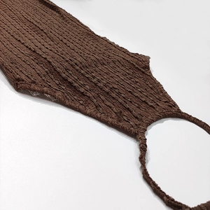 Detail of coffee brown pleated fabric showing ribbed texture and ring halter neckline