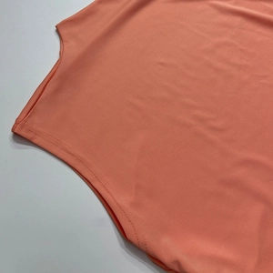 Detailed view of coral sleeveless dress featuring high-quality double-needle stitching