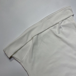 Détail de la robe bustier blanche montrant les coutures fines et la taille à revers