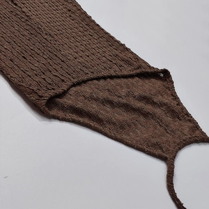 Detailed close-up of brown popcorn fabric texture on a backless knitted summer maxi dress