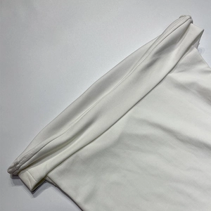 Détail de la texture du tissu blanc élastique et des coutures fines sur la robe bustier