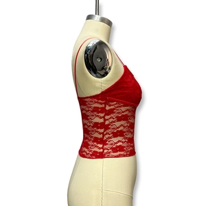 Detail view of red lace camisole showing delicate hollow-out texture and slim straps