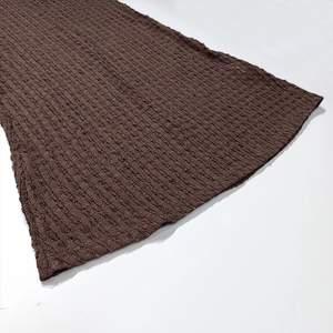 Detailed macro view of the dark brown pleated knit fabric with elastic wavy texture