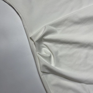 Gros plan sur un tissu blanc en maille fine montrant une texture lisse et un beau drapé