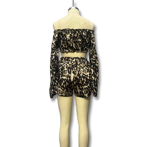 Detail van de satijnen stof met luipaardprint en de off-shoulder top met lange mouwen