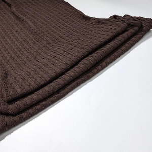Detailed macro view of the textured brown bubble knit fabric with 3D pleated design