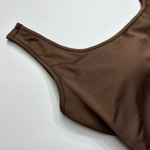 Détail de la double couture sur le body dos nu marron foncé en tissu haut de gamme
