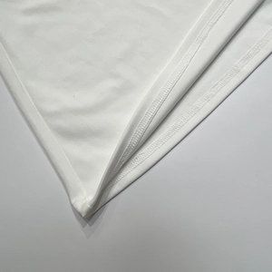 Gros plan détaillé montrant la couture à double point sur l'ourlet en tissu blanc
