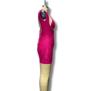 Détail du tissu en dentelle florale rose vif et découpes de la robe dos nu moulante