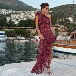 Detail of red floral dress featuring one-shoulder bow design and ruffled asymmetrical hem
