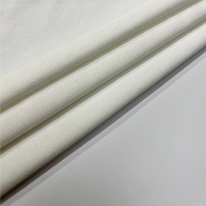 Détail montrant la texture lisse et la superposition douce du tissu en coton blanc premium